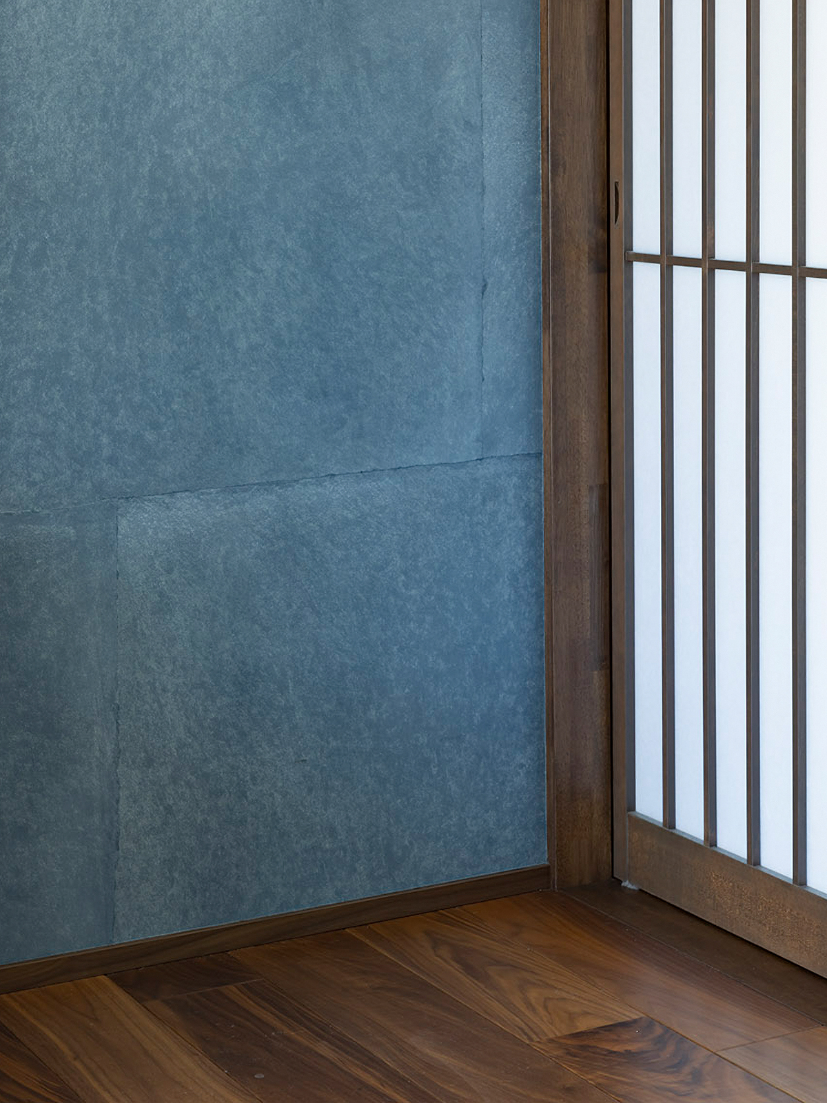 青い和紙貼りの壁と縦格子建具のディテール