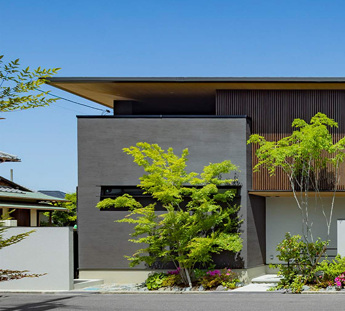 縦格子と植栽が調和する二階建ての外観